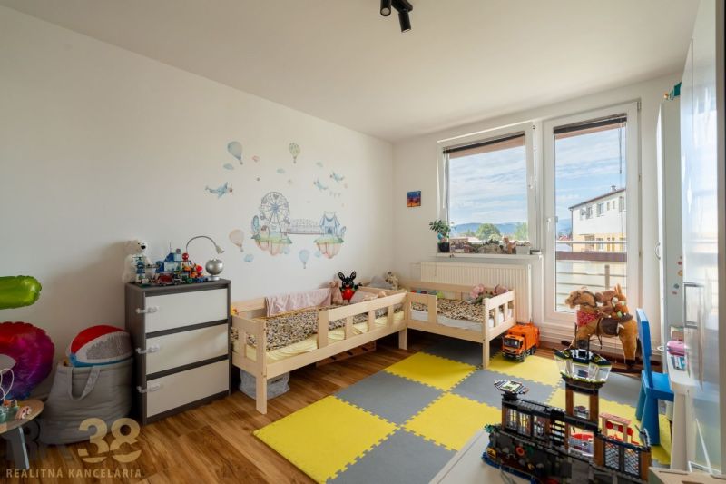 Kompletne zrekonštruovaný 3-izbový byt s priestranným balkónom - Detská izba s dvomi posteľami a nálepkami v 3-izbovom byte, podlaha s dreveným dekorom.