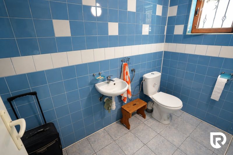 Investičná Príležitosť Chata - RD pri SKI MAKOV 4 959 m² pozem. - Kúpeľňa v rodinnom dome s modrými kachličkami, umývadlom a WC.