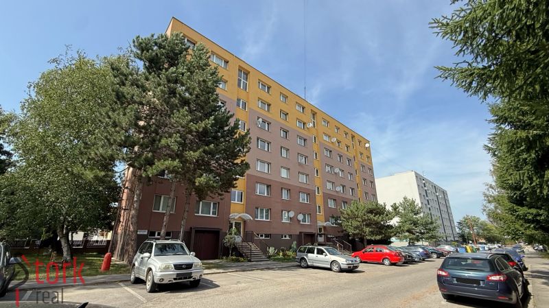 Na predaj - 2i BYT v pôvodnom stave - JUH - Rajec - Ulica Mudrochova v Rajci ukazuje bytový dom a parkovisko pre 2-izbové byty.