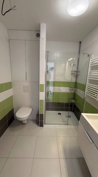 2- izbový byt na  Roľníckej ulici  - Kúpeľňa s toaletou a sprchovým kútom v 2-izbovom byte, svetlé obklady a podlahy.
