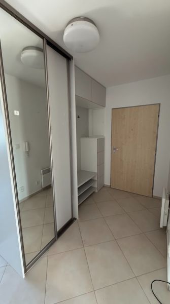 2- izbový byt na  Roľníckej ulici  - Vstupná chodba so zrkadlovou skriňou a svetlou dlažbou v 2-izbovom byte.