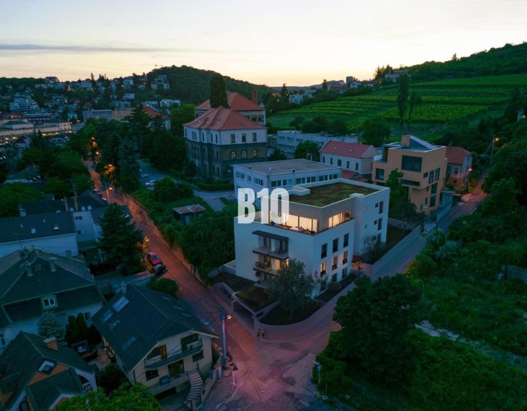 BRATISLAVA NA DLANI - SKOLAUDOVANÝ BYT S TERASOU, NA NAJVYŠŠOM POSCHOD - Večerný pohľad na Pod Strážami v Bratislave III s vinicami a 3-izbovými bytmi.