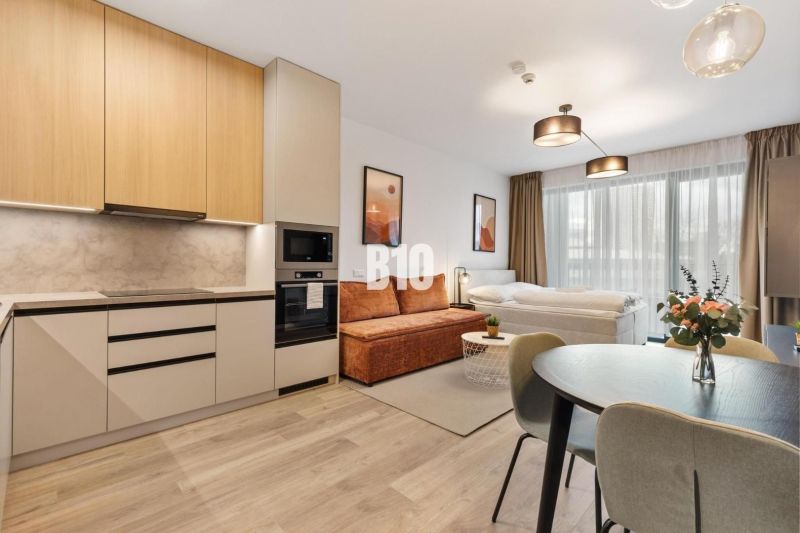 DOWNTOWN NA DOSAH – DIZAJNOVÝ 1-izbový apartmán s loggiou a výhľadom n - Kuchyňa a obývacia časť 1-izbového bytu s podlahou s dreveným dekorom.