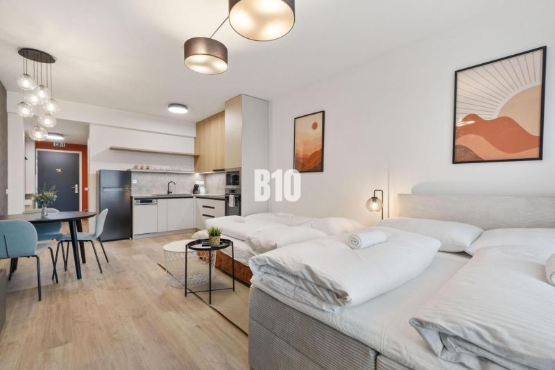 DOWNTOWN NA DOSAH – DIZAJNOVÝ 1-izbový apartmán s loggiou a výhľadom n - Štýlový 1-izbový byt s podlahou s dreveným dekorom a útulným nábytkom.