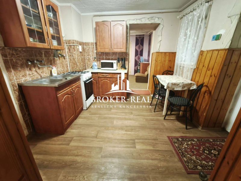 Rodinný dom 4 - izbový, Bódvaszilas, Maďarsko - Kuchyňa v rodinnom dome s dreveným dekorom, skrinky a jedálenský kút.