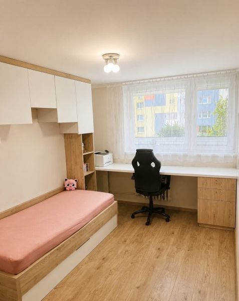 4,5- izbový mezonet na ulici Saratovská - Izba s posteľou, pracovným stolom, kreslom a podlahou s dreveným dekorom, piatich izbový byt.