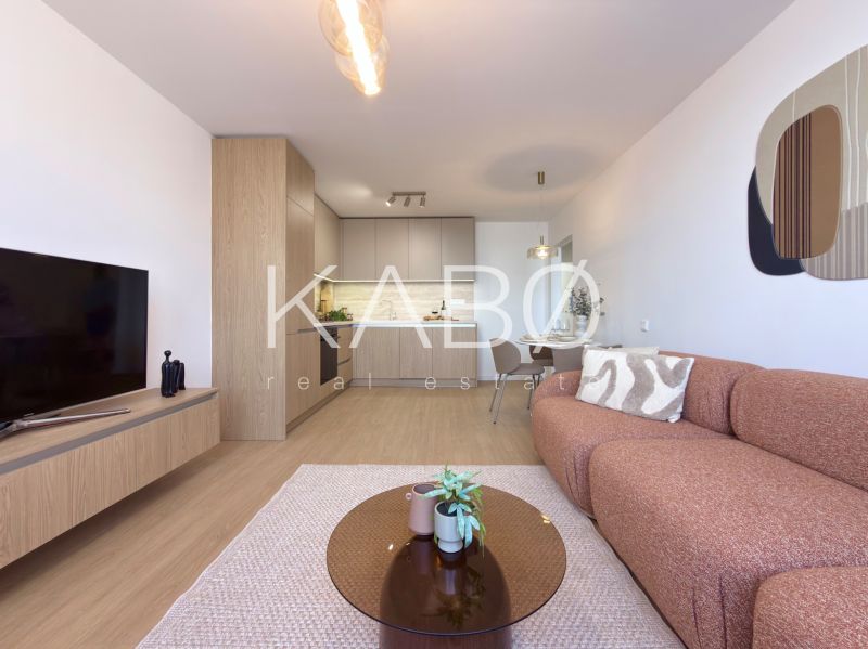 Moderný 3 izbový byt s balkónom a výhľadom na Zobor - Chrenová - Obývacia izba v 3-izbovom byte s podlahou s dreveným dekorom a svetlým nábytkom.