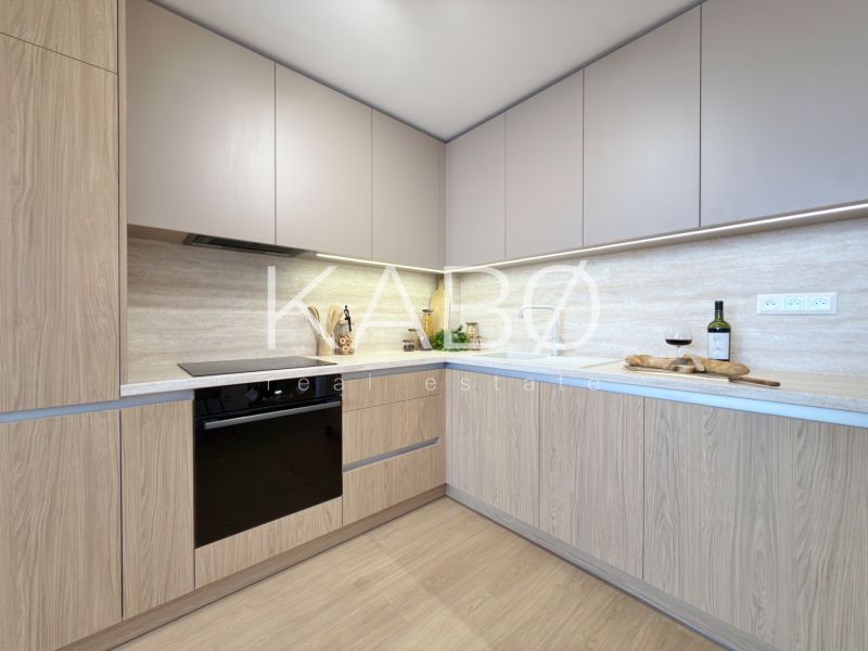 Moderný 3 izbový byt s balkónom a výhľadom na Zobor - Chrenová - Kuchyňa v 3-izbovom byte s podlahou s dreveným dekorom a zabudovanými spotrebičmi.