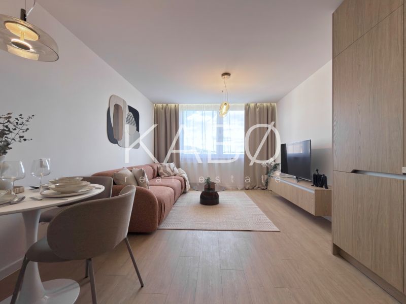 Moderný 3 izbový byt s balkónom a výhľadom na Zobor - Chrenová - Obývacia izba v 3-izbovom byte s podlahou s dreveným dekorom, pohovkou a jedálenským stolom.