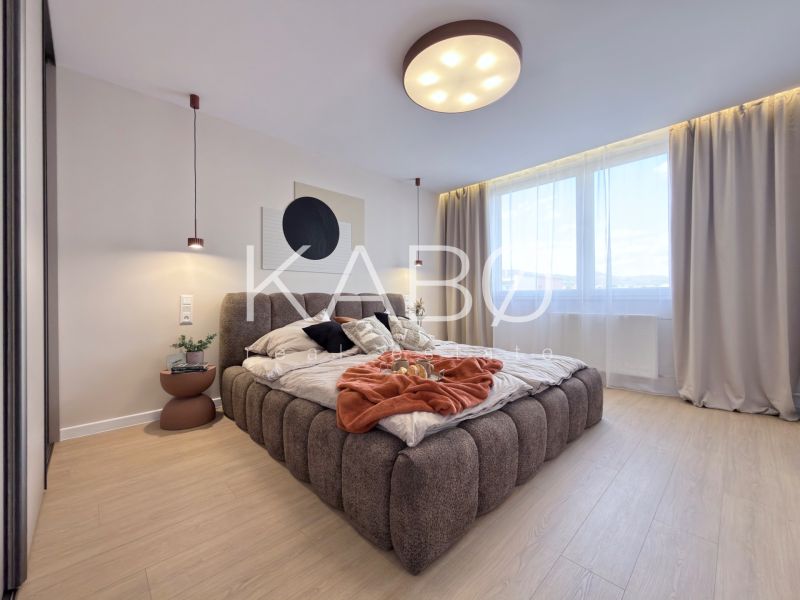 Moderný 3 izbový byt s balkónom a výhľadom na Zobor - Chrenová - Svetlá spálňa s veľkou posteľou a podlahou s dreveným dekorom v 3-izbovom byte.