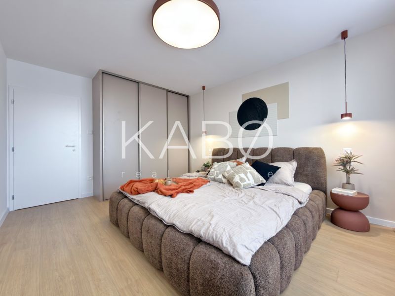 Moderný 3 izbový byt s balkónom a výhľadom na Zobor - Chrenová - Spálňa v 3-izbovom byte s veľkou posteľou a podlahou s dreveným dekorom.