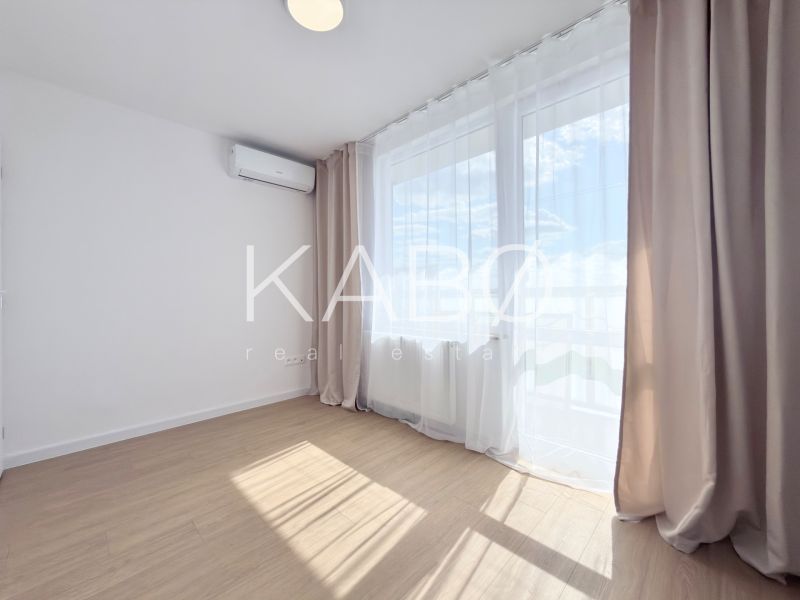 Moderný 3 izbový byt s balkónom a výhľadom na Zobor - Chrenová - Izba s podlahou s dreveným dekorom a klimatizáciou v 3-izbovom byte.