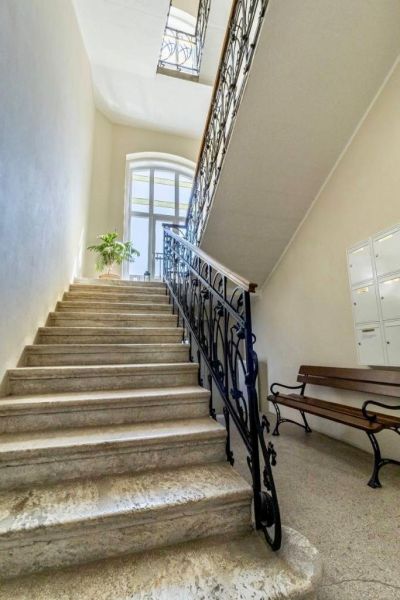 NA PRENÁJOM-Kancelársky priestor-Košice-Staré mesto,Masarykova ul. - Schodisko s kovovým zábradlím a lavicou v Kanceláriách, osvetlené veľkým oblúkovým oknom.