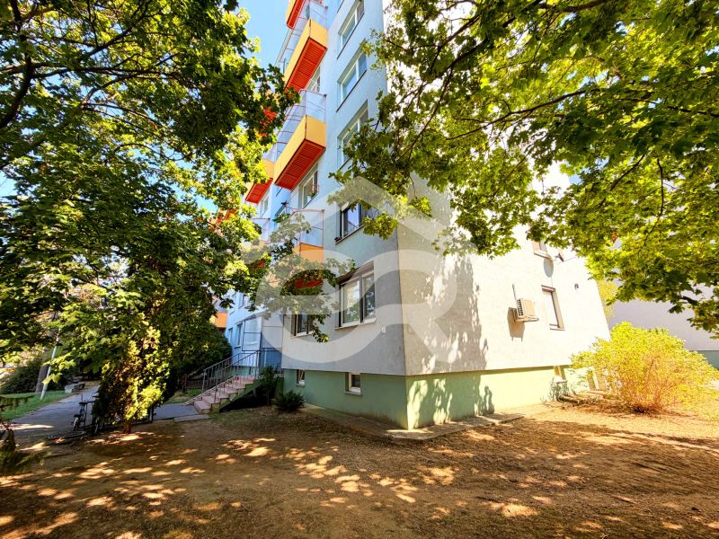 Na predaj kompletne prerobený 1 izbový byt, Vráble - Lúky, 36m2, 7/7 - Bytovka s farebnými balkónmi na ulici Lúky vo Vrábľoch, obklopená stromami.