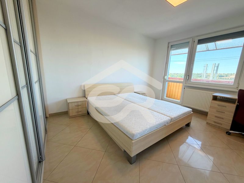 Na predaj kompletne prerobený 1 izbový byt, Vráble - Lúky, 36m2, 7/7 - Svetlá spálňa v 1-izbovom byte s posteľou, skriňou a balkónom.