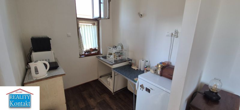 Na predaj 2 izbový tehlový byt 45m2 - Nové Zámky  - Kuchyňa v 2-izbovom byte so spotrebičmi a podlahou s dreveným dekorom.