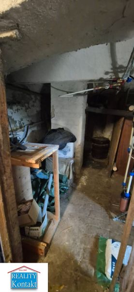 Na predaj 2 izbový tehlový byt 45m2 - Nové Zámky  - Suterénny priestor v 2-izbovom byte so skladovacími policami a potrubiami.