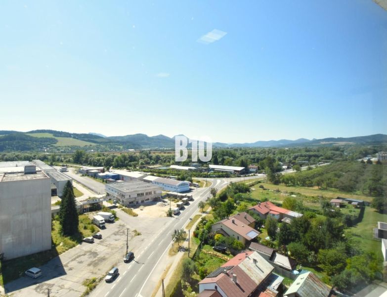 Moderný 3-izbový byt s pekným výhľadom - Pohľad na krajinu a zástavbu Bytče z výšky, vidno cestu a budovy.