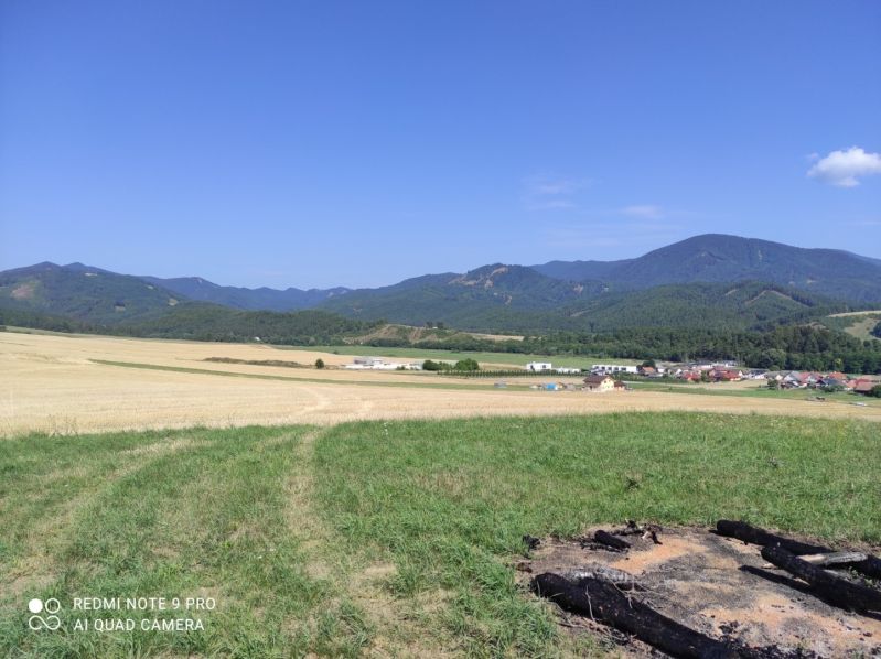 VALČA pozemok s výmerou 5800 m2,  okr. Martin  - Na obrázku je malebná krajina, lúky, polia a vzdialené hory. V pozadí vidieť domy.
