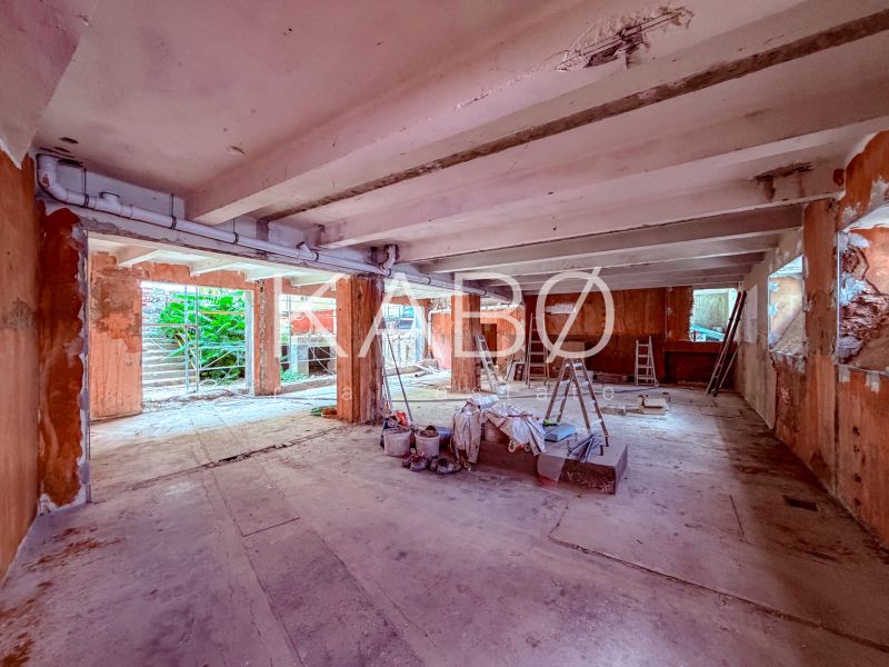 Industriálny obchodný priestor v úplnom centre mesta - 137 m2 - Rozostavané obchodné priestory s betónovou podlahou, rebríkmi a stavebným materiálom.