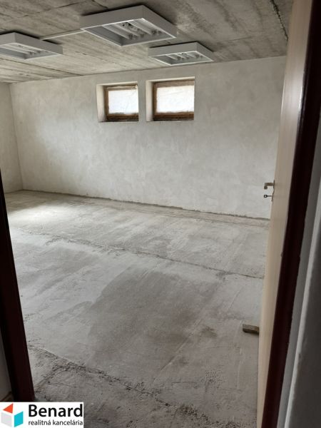 Rozostavaný rodinný dom Plavnica - Nevybavená miestnosť v rodinnom dome s dvoma malými oknami a surovou podlahou.
