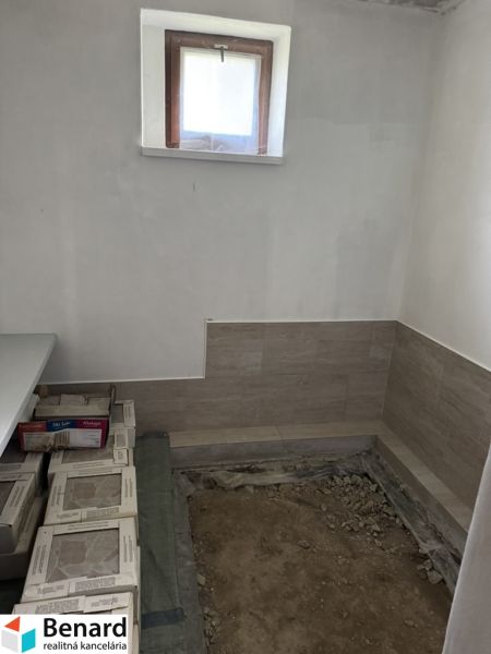Rozostavaný rodinný dom Plavnica - Interiér rodinného domu s oknom a brúsenou podlahou, príprava na dlažbu.