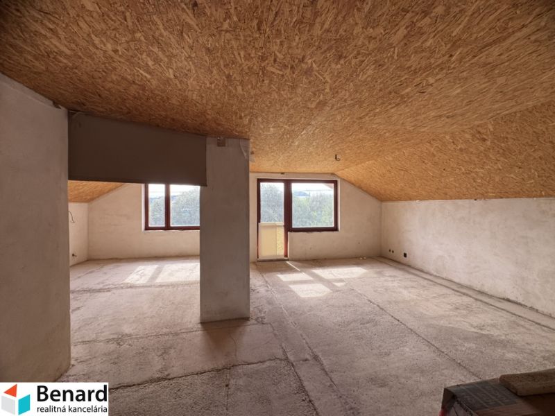 Rozostavaný rodinný dom Plavnica - Podkrovný priestor v rodinnom dome s veľkými oknami a výhľadom.