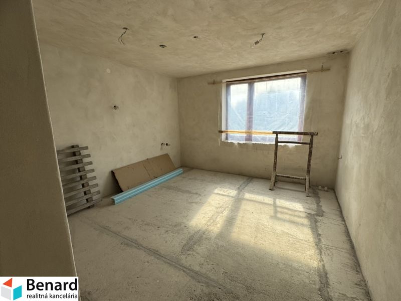 Rozostavaný rodinný dom Plavnica - Nezariadená miestnosť v rodinnom dome s veľkým oknom a holými stenami.