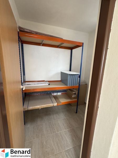 Rozostavaný rodinný dom Plavnica - Úložný priestor v rodinnom dome s policovým regálom a podlahou s dreveným dekorom.