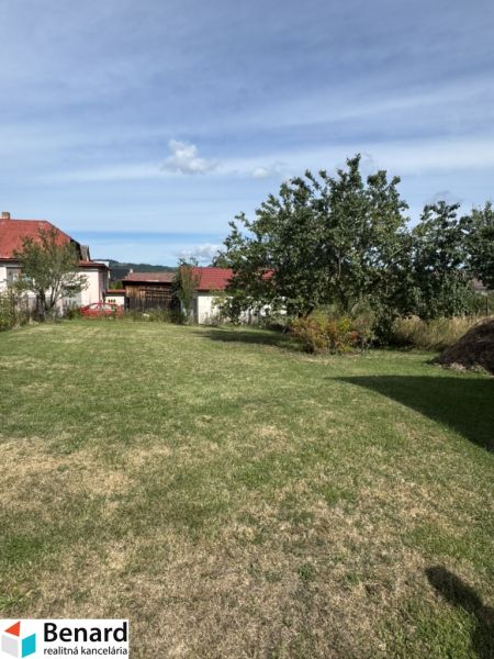 Rozostavaný rodinný dom Plavnica - Záhrada pred rodinným domom v Plavnici, trávnatá plocha a zeleň pod belasou oblohou.