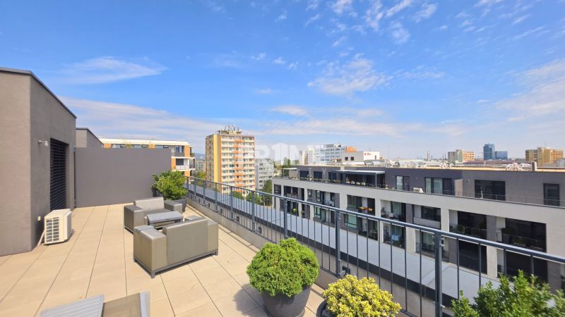 PENTHOUSE – moderný 2i byt s výnimočnou 69 m² terasou, AHOJ PARK - Terasa v 2-izbovom byte na Sliačskej ulici, Bratislava - Nové Mesto s výhľadom na mesto.