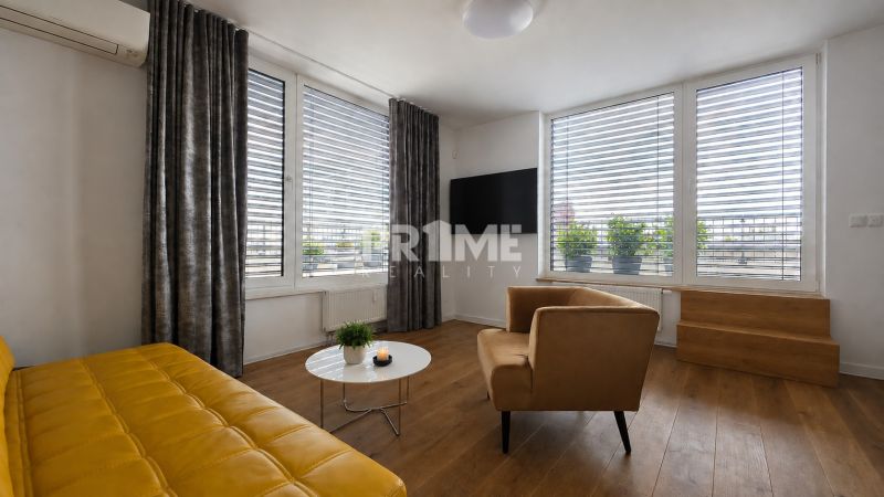 PENTHOUSE – moderný 2i byt s výnimočnou 69 m² terasou, AHOJ PARK - Obývacia izba s podlahou s dreveným dekorom a žltou pohovkou v 2-izbovom byte.