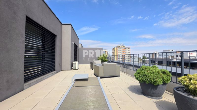 PENTHOUSE – moderný 2i byt s výnimočnou 69 m² terasou, AHOJ PARK - Terasa 2-izbového bytu na Sliačskej ulici v Bratislave - Nové Mesto so zeleňou a nábytkom.