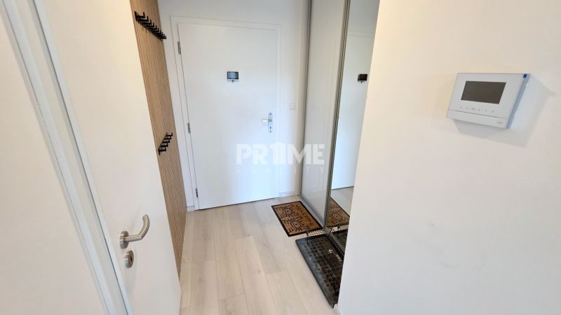 MODERNÝ 3i BYT, NOVOSTAVBA ČEREŠNE, LOGGIA, KLÍMA, PARKING, Polianky - Vstupná chodba s bielymi dverami, dreveným vešiakom a šatníkovou skriňou v 3-izbovom byte.