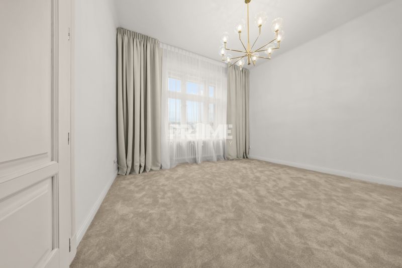  EXKLUZÍVNY, VEĽKOMETRÁŽNY 3i byt ( 130 m2 ), REKONŠTRUKCIA, CENTRUM - Elegantný priestor s kobercom, záclonami a zlatým lustrom v 3-izbovom byte.