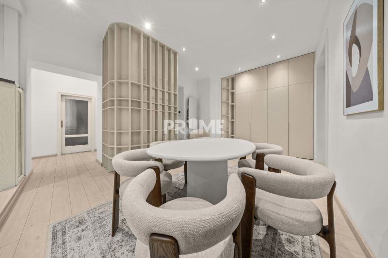  EXKLUZÍVNY, VEĽKOMETRÁŽNY 3i byt ( 130 m2 ), REKONŠTRUKCIA, CENTRUM - Interiér 3-izbového bytu s podlahou s dreveným dekorom, okrúhlym stolom a stoličkami.