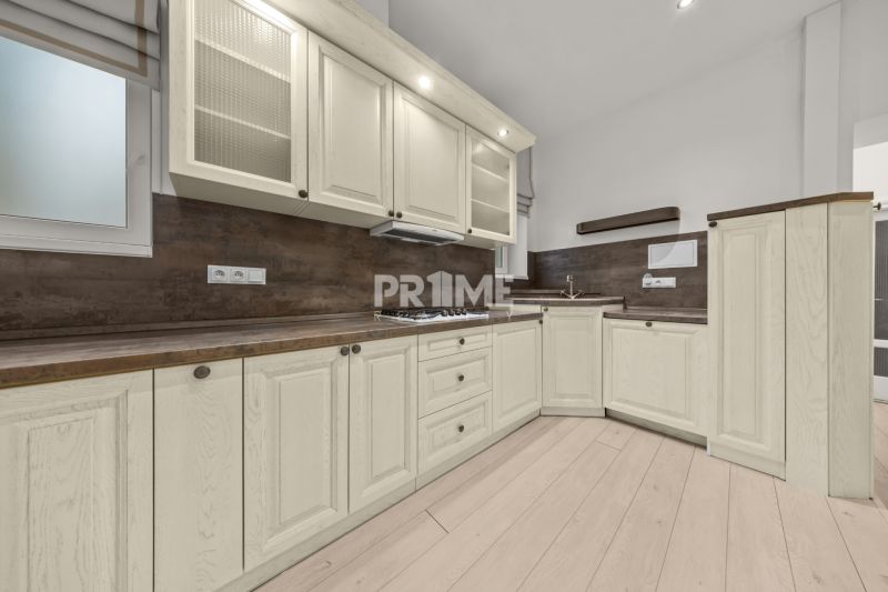  EXKLUZÍVNY, VEĽKOMETRÁŽNY 3i byt ( 130 m2 ), REKONŠTRUKCIA, CENTRUM - Kuchyňa v 3-izbovom byte s bielymi skrinkami a podlahou s dreveným dekorom.