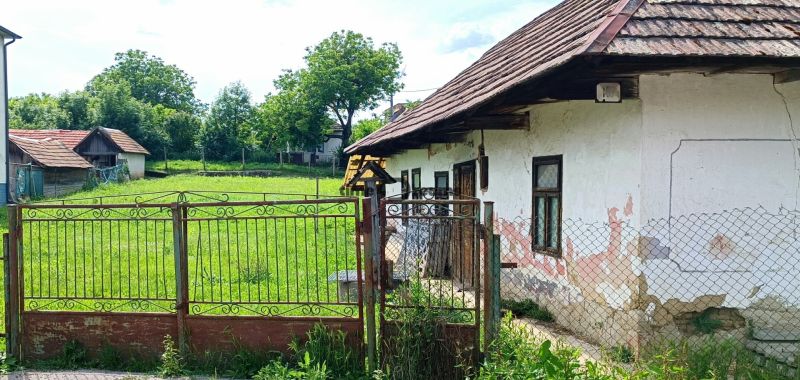 NA PREDAJ stavebný pozemok  v Plavých Vozokanoch - Starší dom so zanedbanou fasádou, bránou a rozľahlým pozemkom, vhodný na rekonštrukciu, bývanie.