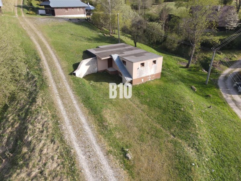 Rozostavaná chata, 845m2 pozemok, platné stavebné povolenie - Malá budova v prírode v okolí Zázrivej, vedľa cesty popri chate.