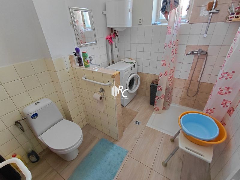 Rodinný dom Martin – Podháj, 5 izieb a pozemok 621 m² - Kúpeľňa v rodinnom dome s práčkou, sprchovým kútom a toaletou, podlaha s dreveným dekorom.
