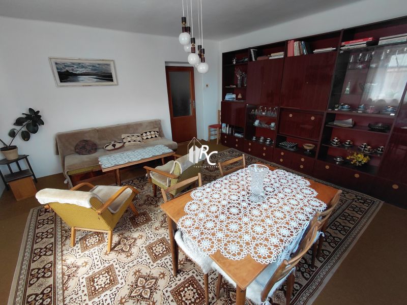 Rodinný dom Martin – Podháj, 5 izieb a pozemok 621 m² - Obývacia izba v rodinnom dome s retro kobercom, nábytkom a závesnou lampou.