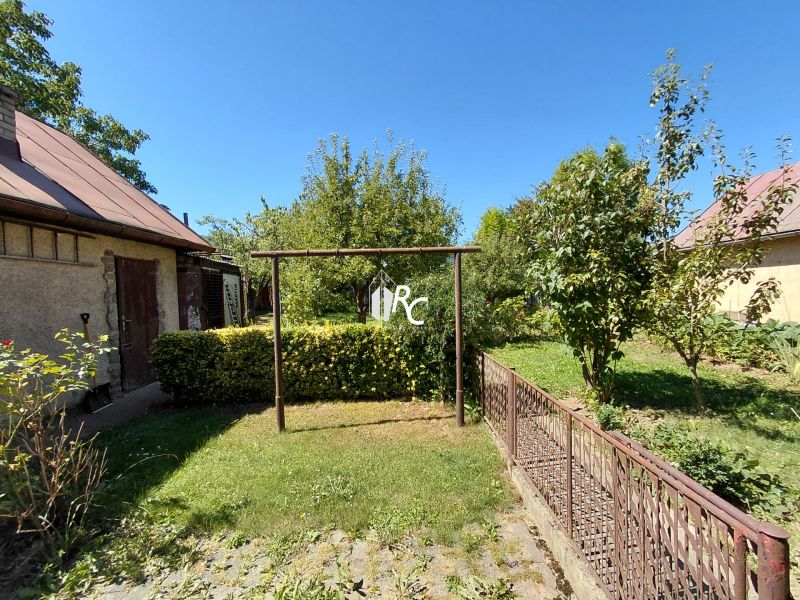 Rodinný dom Martin – Podháj, 5 izieb a pozemok 621 m² - Rodinný dom na ulici Riečiny v Martine s trávnikom a stromami v záhrade.