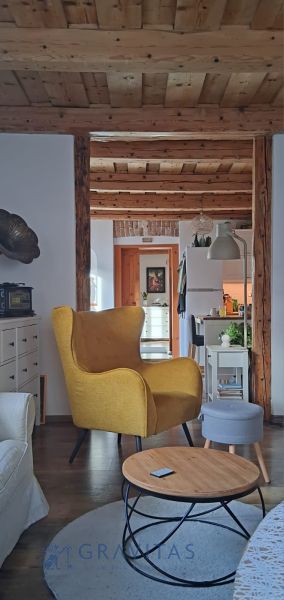 Na predaj rodinný dom, Blatnica - Interiér rodinného domu s dreveným stropom a pohodlným žltým kreslom.