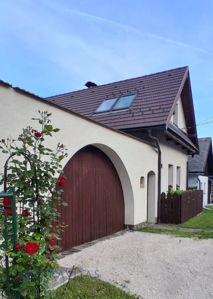 Na predaj rodinný dom, Blatnica - Rodinný dom v Blatnici s tehlovou strechou a kvetmi pozdĺž plotu.