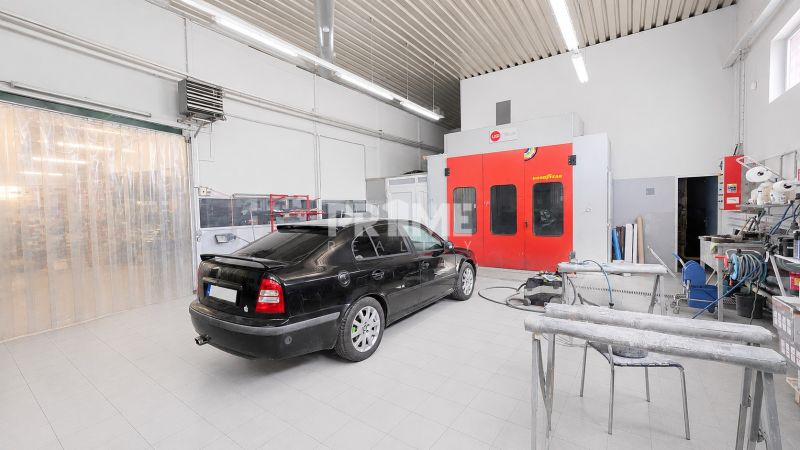 MODERNÝ, ZABEHNUTÝ, KOMPLETNE ZARIADENÝ AUTOSERVIS, LOZORNO - Výrobné priestory s automobilom a vybavením na dlažbovej podlahe pod osvetlením.