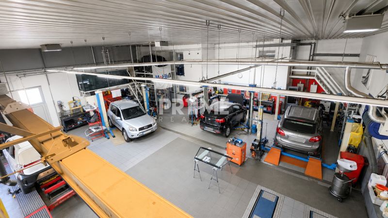 MODERNÝ, ZABEHNUTÝ, KOMPLETNE ZARIADENÝ AUTOSERVIS, LOZORNO - Autodielňa s automobilmi v servisných priestoroch s profesionálnym vybavením a nástrojmi.