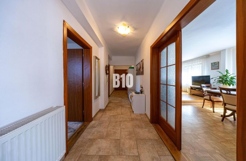 Priestranný 5-izbový rodinný dom (190 m²) s krásne upraveným 13a pozem - Chodba s dlažbovou podlahou vedúca do obývačky v rodinnom dome, drevené dvere.