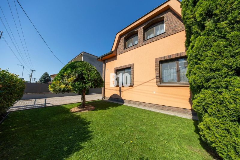 Priestranný 5-izbový rodinný dom (190 m²) s krásne upraveným 13a pozem - Rodinný dom na Bratislavskej ulici v Malinove s upravenou záhradou a stromom.