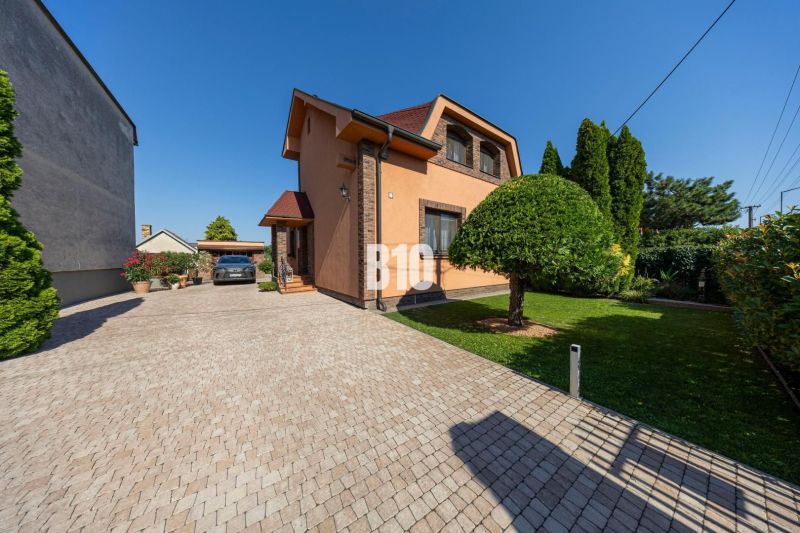 Priestranný 5-izbový rodinný dom (190 m²) s krásne upraveným 13a pozem - Rodinný dom na Bratislavskej ulici v Malinove s upravenou záhradou a kamenným chodníkom.