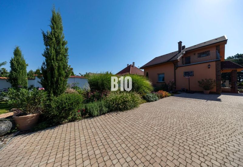 Priestranný 5-izbový rodinný dom (190 m²) s krásne upraveným 13a pozem - Rodinný dom na Bratislavskej ulici v Malinove obklopený udržiavanou záhradou a dlažbou.